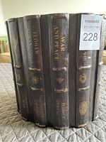 Close-up of the trash can showing the design imitating vintage book spines including 'War and Peace' and 'Flower'.
