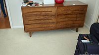 Front view of dresser showing six drawers with integrated wood pulls and overall condition