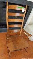 Front view of wooden rocking chair showing ladder-back design and armrests