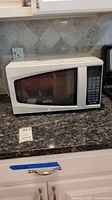Full view of the white Sunbeam microwave oven placed on a kitchen counter.
