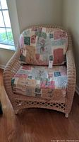 Front view of the wicker chair with fabric cushions showing the full seating and backrest area