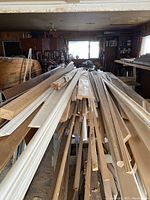 Wide view showing large quantity of lumber boards stacked on racks in a workshop environment