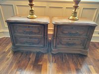 Full view of pair of matching wooden vintage night tables with lamps on top, showing front and side details