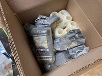 Box with four packages of Rhodes American steel wool pads and six white paint rollers showing packaging and condition.