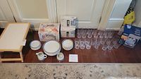 Overview of folding tray, dishes, cream and sugar set, boxes of glasses, kettle