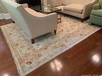 Full room view of the cream and red Persian rug under seating