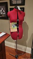 Full view of red adjustable sewing dress form on chrome tripod base