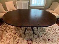 Table assembled with leaf in place on area rug, chairs pushed back