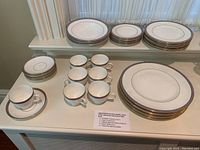 Photo showing stacks of dinner plates, side plates, bread and butter plates, soup bowls, and arranged teacups with saucers featuring the Wedgwood Palatia design.
