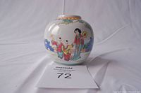 Porcelain jar front view showing painted figures of a woman and two children with garden elements.