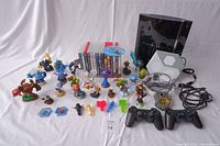 Full lot overview showing PS3 console, controllers, game cases, numerous Skylanders figurines, and portal devices with cables.