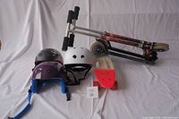 Overview of two scooters, skateboard, and three helmets