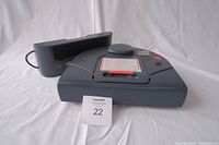 Front view of the Neato Robotics robot vacuum cleaner with charging dock in background