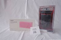 Boxed Miniso pink wireless speaker and Canon style Lens Mug in original packaging.