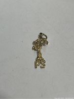 Full view of the 14kt gold palm tree pendant with PS initials at the base on a white background.