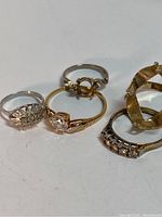 Five gold filled rings displayed on white background including two 18k rings without stones and three 14k rings with stones.