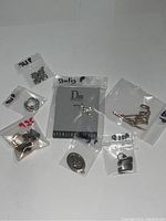 Overview of various sterling silver earrings and pendants sorted in plastic bags with labels showing '925' and 'Sterling'
