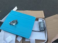 Large blue platform scale with white metal stand in open cardboard box with foam padding.