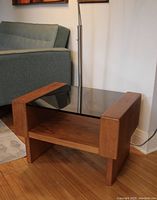 Front view of teak side table next to sofa, showing overall design and proportions.