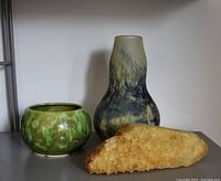 Photo showing all three items together: the green glazed ceramic pot, blue-green mouthblown glass vase, and large yellow crystal specimen.