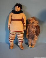 Full view of both Inuit dolls, showing size difference and traditional clothing styles.