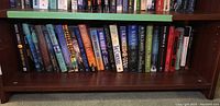 Shelf of books showing a mix of hardcover and paperback editions with varied titles and authors.