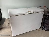 Front and top view of Kenmore white chest freezer, showing solid rectangular shape with top lid and handle.