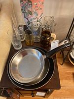 Photo of three frying pans stacked showing size differences and handle styles.