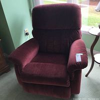Front view of burgundy La-Z-Boy manual recliner chair showing cushioned seat, armrests, and backrest.