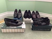 Five pairs of women's shoes in size 7, placed on and around shoeboxes, various styles shown