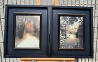 Two framed pictures side by side on an easel, showing nature paths and trees in black frames.