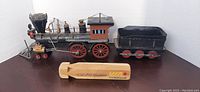 Photo of the metal model train engine and coal tender showing detailed parts and wheels.
