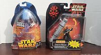Two Star Wars figures in sealed packaging: Yoda and Darth Maul, shown front view.