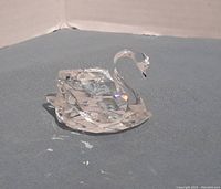 Photo of the clear faceted Swarovski mini swan figurine showing its detailed curved neck and reflecting light.