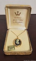 Vintage 12K gold filled necklace with hand carved cameo locket displayed in the original box with 'Hand Carved Cameo' tag visible.