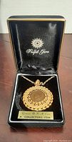 Photo of the vintage necklace in its original black box, showing the gold-tone pendant with the 1897 USA coin embedded.