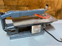 Side view of Busy Bee 15 inch scroll saw showing full body and work surface with blade guard.