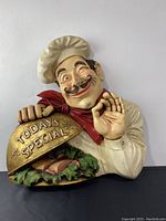 Front view of the Italian chef wall sign showing the chef holding the Today’s Special cloche with food.