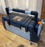 Front view of a large Tactix toolbox mostly black and silver, showing metal latches and handle