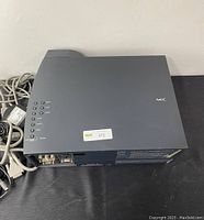 Top view of NEC projector showing control buttons and cables attached.