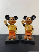 Pair of dark-colored vintage Mickey Mouse night light table lamps standing side by side on black bases with knob switches.
