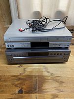 Top view showing Panasonic VHS DVD Combo unit with attached AV cables and the JVC 5-disc CD player unit beneath it