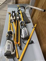 Multiple power heads, shafts and attachments laid out on table