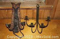 Photo showing both wall mount candle holders on a wooden surface.