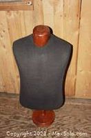 Front view of large display mannequin bust showing black fabric torso and wooden neck.