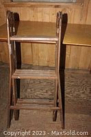 Side view of the brown metal folding ladder showing two sections and the steps.