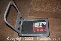Top view of the folding moving cart with handle raised and some paper on the platform.