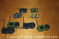 Four remote control mini tanks in different camouflage colors with four respective controllers.