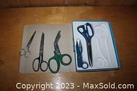 Overview of six different scissors and cutting tools on wooden surface and tray