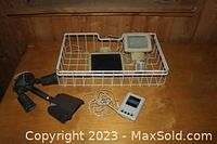 Photo of the solar light and digital thermometer placed in a white wire basket on a wooden surface.